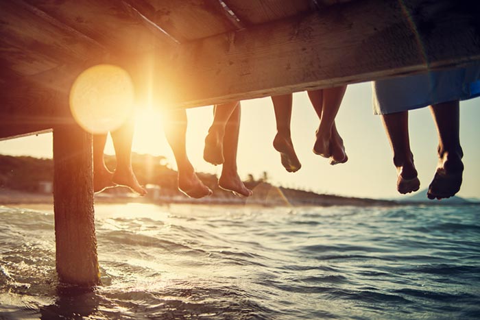 People sitting on wharf on sunset